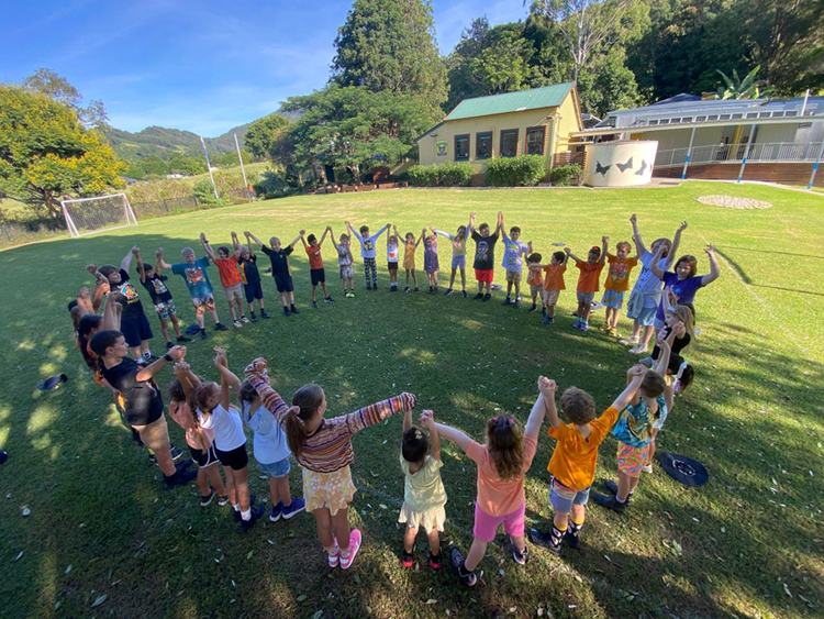 K-6 students in a circle holding hands on Harmony Day