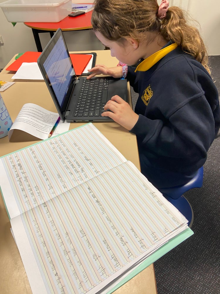 A student publishing her writing on a laptop