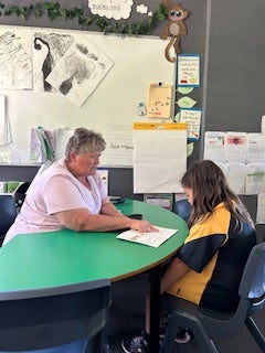 An SLSO listening to a student read